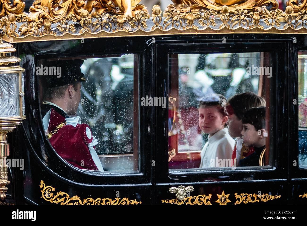 Rainy London vede la principessa Charlotte e i principi George e Louis cavalcare con i loro genitori sul pullman diamante dello stato del giubileo il giorno dell'incoronazione. Foto Stock