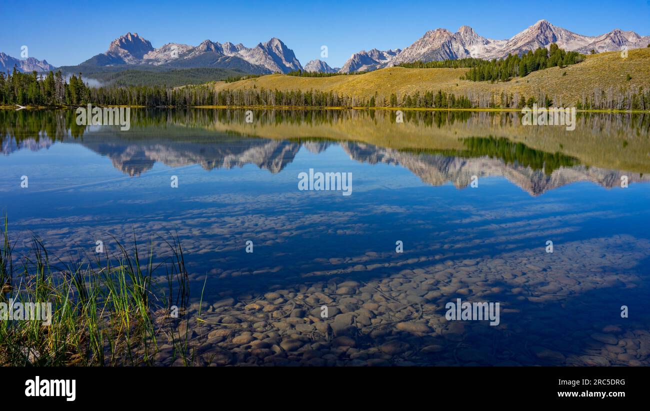 Le Sawtooth Mountains si riflettono nel lago Little Redfish con cielo azzurro | Sawtooth National Recreation area, Idaho, USA Foto Stock