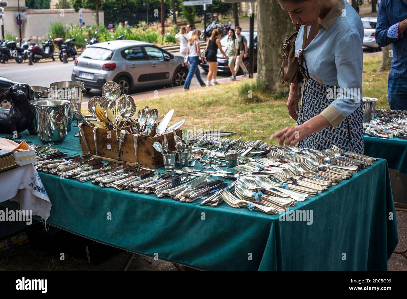 Donna che guarda le posate d'argento al mercato delle pulci Antique a Versailles, Parigi, Francia Foto Stock