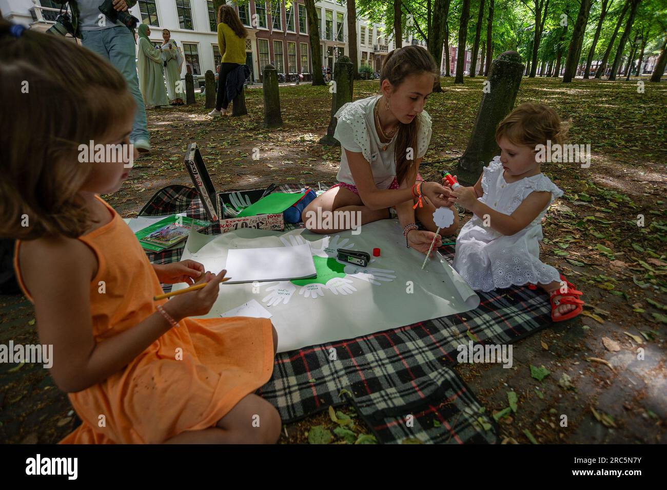 I bambini in gioco, si aprono le mani con il nome di un bambino che oggi ha partecipato alla Lange Voorhout all'Aia, per commemorare il massacro etnico del 1995 di oltre ottomila vittime del genocidio di Srebrenica. Dal 1997, il genocidio di Srebrenica si tiene ogni anno l'11 luglio a Het Plein a l'Aia. Un cambio di sede per l'evento di oggi tenutosi a Lange Voorhout. In questo giorno, più di ottomila vittime del genocidio di Srebrenica sono commemorate. Queste persone sono state uccise nel 1995 da un'aggressione nazionalista radicale serba e serbo-bosniaca, dopo l'en Foto Stock