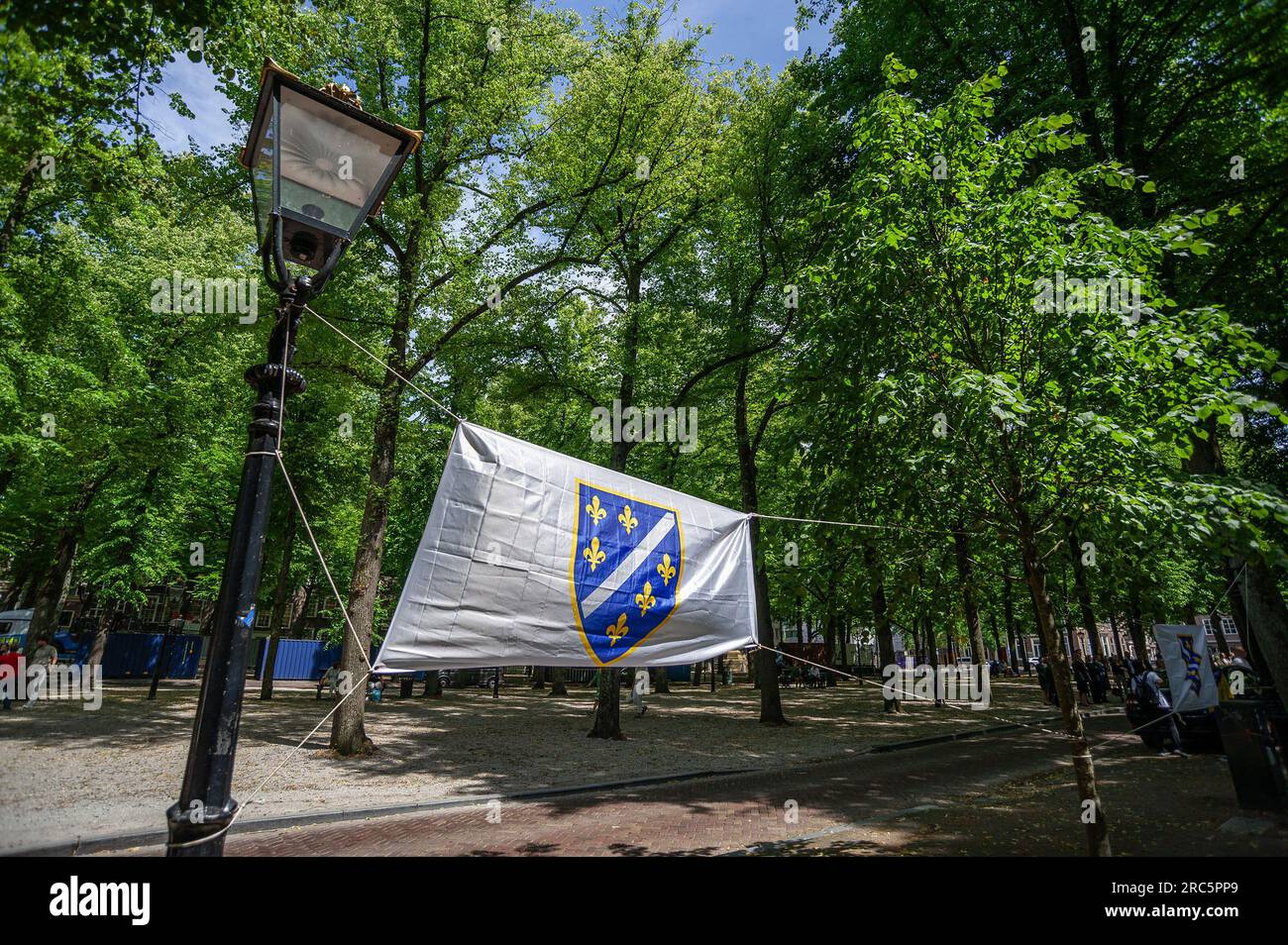 11 luglio 2023, l'Aia, Paesi Bassi: La bandiera della Repubblica di Bosnia-Erzegovina, volata oggi sul Voorhout Lange all'Aia per commemorare il massacro etnico del 1995 di oltre ottomila vittime del genocidio di Srebrenica. Dal 1997, il genocidio di Srebrenica si tiene ogni anno l'11 luglio a Het Plein a l'Aia. Un cambio di sede per l'evento di oggi che si tiene a Lange Voorhout. In questo giorno, più di ottomila vittime del genocidio di Srebrenica sono commemorate. Queste persone furono uccise nel 1995 dai nazionalisti radicali serbi e dai serbi bosniaci Foto Stock