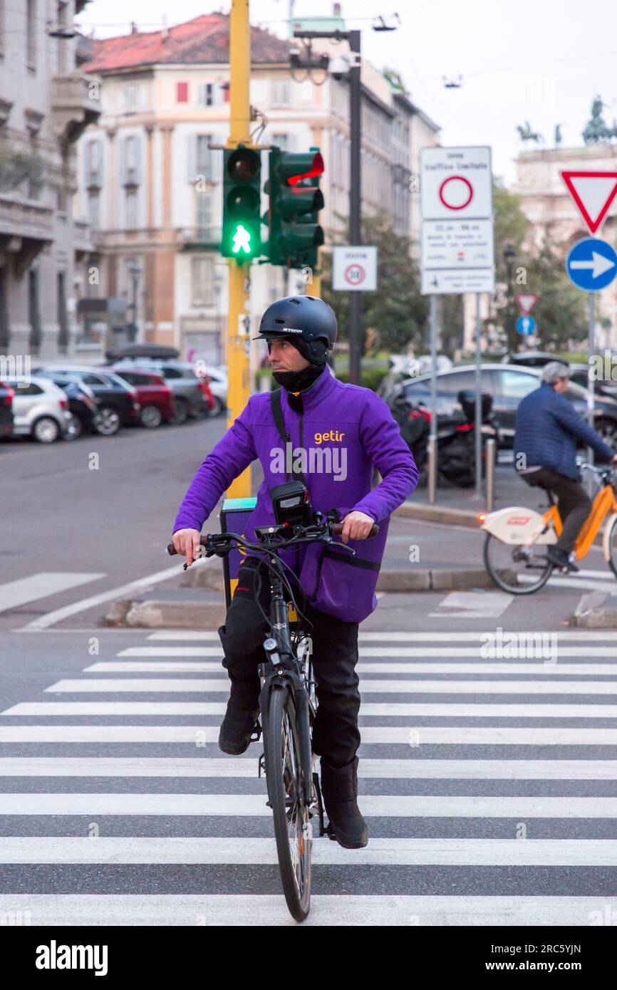 Milano, Italia - marzo 31 2022: Getir deliverer in bicicletta per le strade di Milano. Getir è un'app per la consegna di generi alimentari, cibo, ecc. con sede a Philippbu Foto Stock