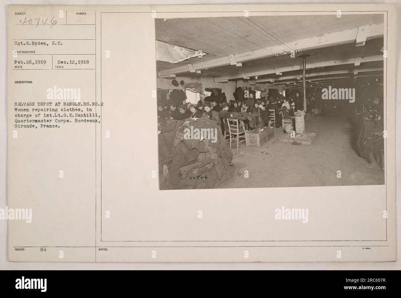 Donne che lavorano al Salvage Depot di Bangle, Bordeaux, Francia durante la prima guerra mondiale Sono mostrati come riparare gli indumenti sotto la supervisione del 1° tenente G.E. Santilli del Quartermaster Corps. Fotografia scattata il 12 dicembre 1918 dal Sgt. G. Ryden. Foto Stock