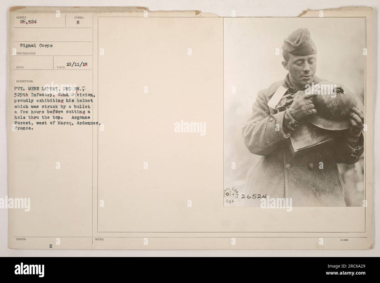 Il soldato Mere Lipsky, del 2nd Battalion del 329th Infantry nella 82nd Division, mostra il suo casco che è stato perforato da un proiettile, lasciando un buco in cima. L'incidente si verificò nella foresta di Argonne, a ovest di Maroq, nella regione delle Ardenne in Francia. La foto è stata scattata l'11 ottobre 1918. Foto Stock