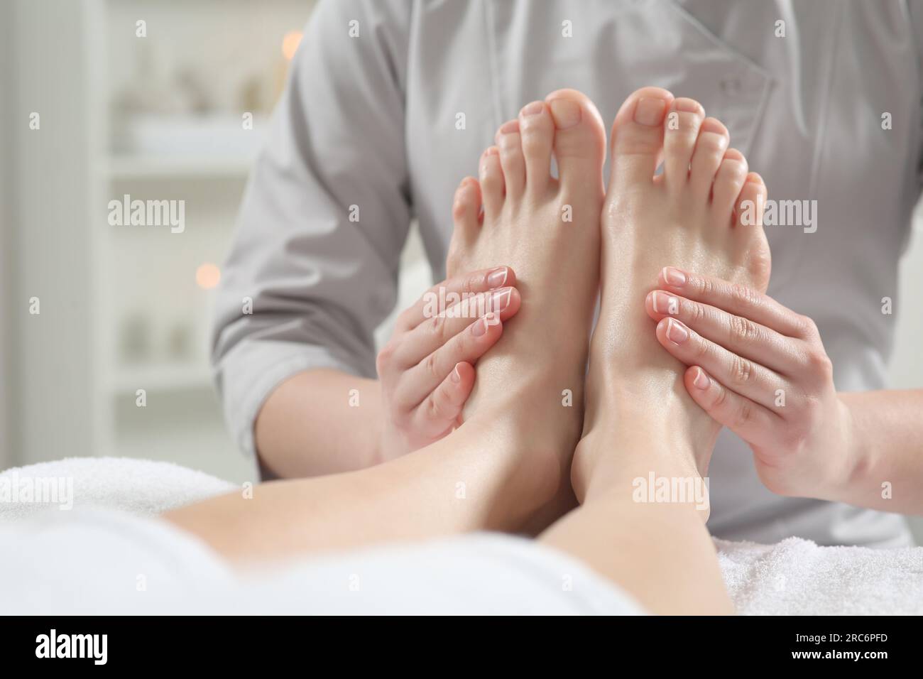 Donna che riceve massaggio piedi nel salone termale, primo piano
