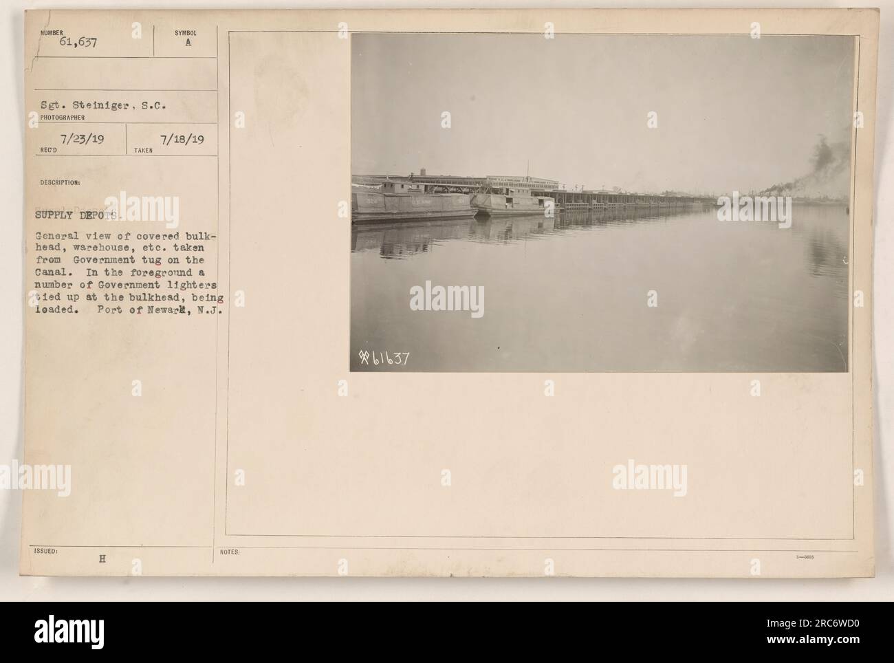 Questa foto è stata scattata il 18 luglio 1919 dal sergente Steiniger, S.C. Mostra una vista di paratie coperte, magazzini e altri edifici presso i depositi di rifornimento nel porto di Newark, New Jersey. In primo piano, diversi accendini governativi sono legati alla paratia e vengono caricati. L'immagine fa parte della collezione di fotografie delle attività militari americane durante la prima guerra mondiale. Foto Stock