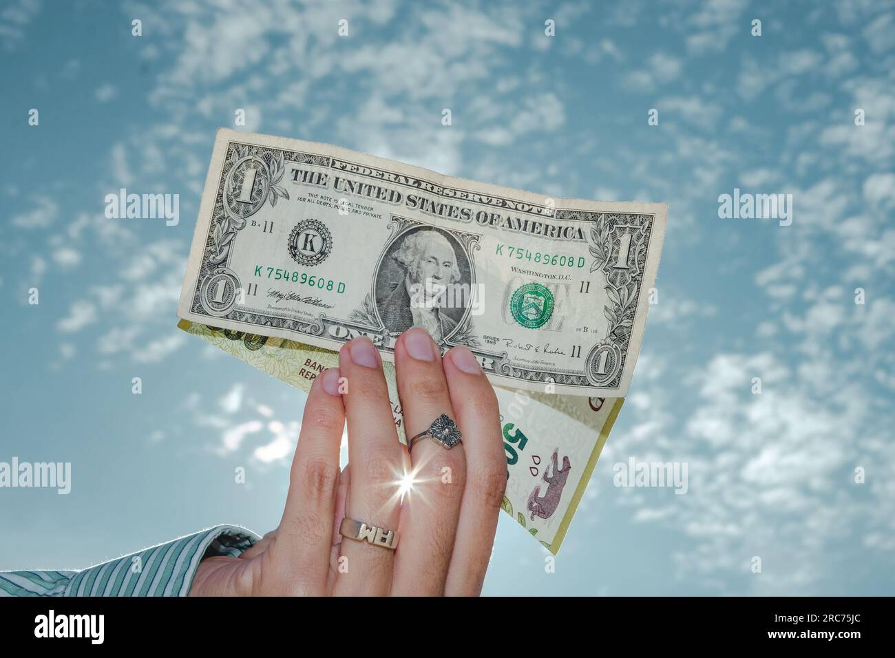 Donna che ha una banconota da un dollaro e 500 pesos argentini. L'economia dell'Argentina. Concetto di inflazione e aumento del dollaro in Argentina Foto Stock