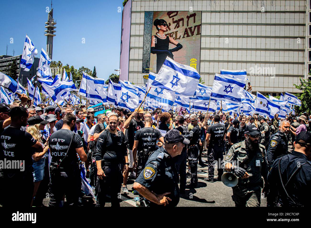 Gerusalemme, Israele. 11 luglio 2023. Gli agenti di polizia israeliani sono in fila mentre affrontano i manifestanti che sventolano le bandiere israeliane durante una manifestazione. La polizia israeliana si è scontrata con i manifestanti in mezzo a enormi manifestazioni contro i controversi piani di riforma giudiziaria del governo. Le proteste sono scoppiate dopo che un disegno di legge per rimuovere il potere della Corte Suprema di rivedere le decisioni dei ministri ha approvato la sua prima lettura in parlamento lunedì sera. Le riforme hanno polarizzato il paese, scatenando mesi di manifestazioni di massa. Credito: SOPA Images Limited/Alamy Live News Foto Stock