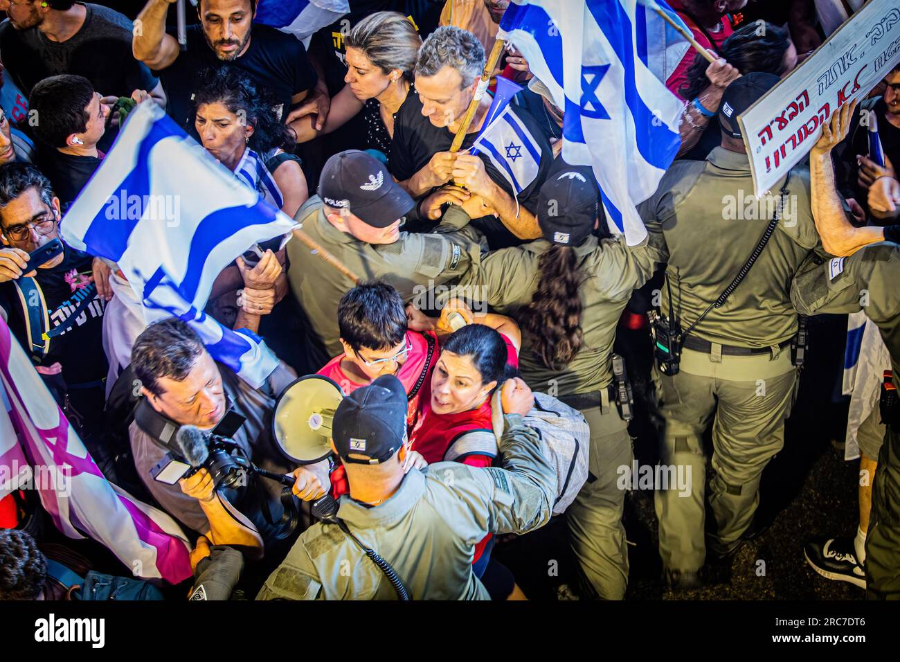 I manifestanti vengono spinti dagli agenti di polizia di frontiera durante una manifestazione all'aeroporto internazionale Ben Gurion. La polizia israeliana si è scontrata con i manifestanti in mezzo a enormi manifestazioni contro i controversi piani di riforma giudiziaria del governo. Le proteste sono scoppiate dopo che un disegno di legge per rimuovere il potere della Corte Suprema di rivedere le decisioni dei ministri ha approvato la sua prima lettura in parlamento lunedì sera. Le riforme hanno polarizzato il paese, scatenando mesi di manifestazioni di massa. (Foto di Eyal Warshavsky/SOPA Images/Sipa USA) Foto Stock