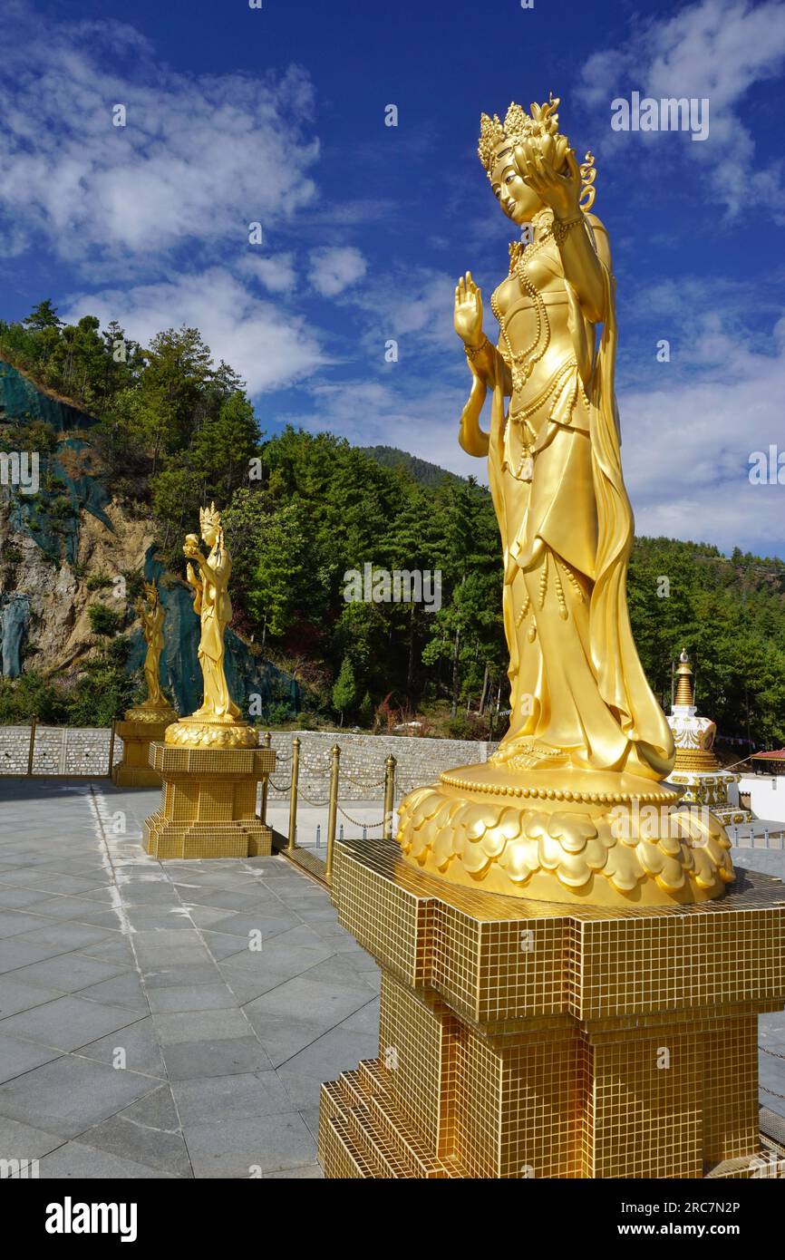 Le lucenti statue dorate delle dee fiancheggiano la terrazza superiore intorno alla statua del Buddha Dordenma nel parco naturale Kuensel Phodrang vicino a Thimphu, Bhutan. Foto Stock