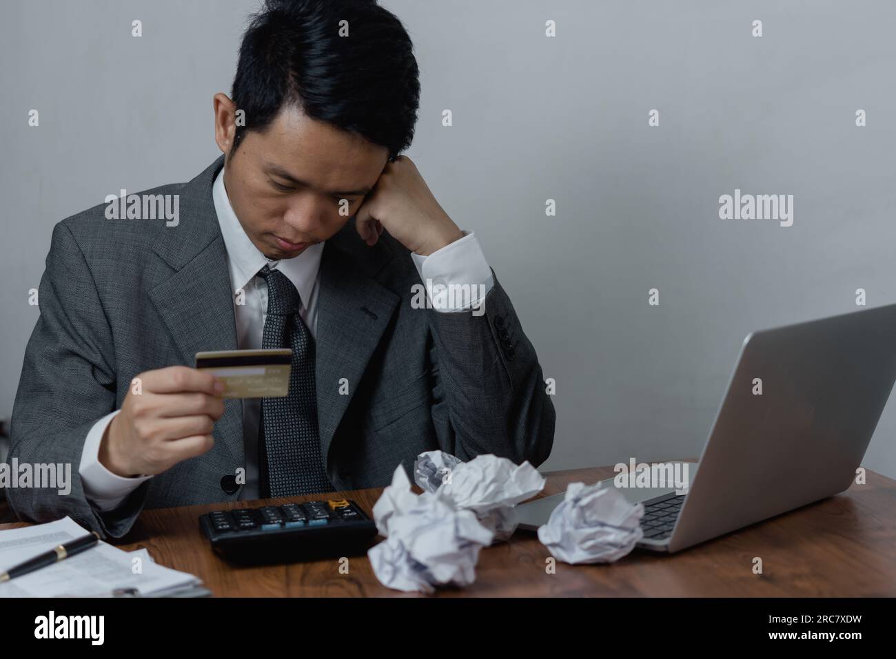 Un uomo d'affari preoccupato, asiatico, che si occupa di debiti con carte di credito e problemi finanziari, controllando il portafoglio e gli estratti conto delle carte di credito. Business banking , pagamento Foto Stock