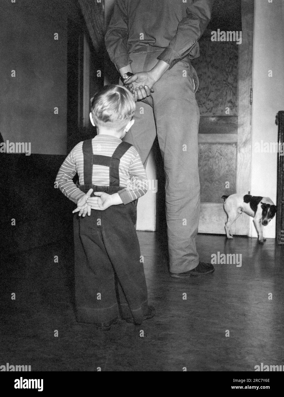 Stati Uniti: c. 1955. Un bambino imita la posa di suo padre nel confrontarsi con il "cane cattivo". Foto Stock