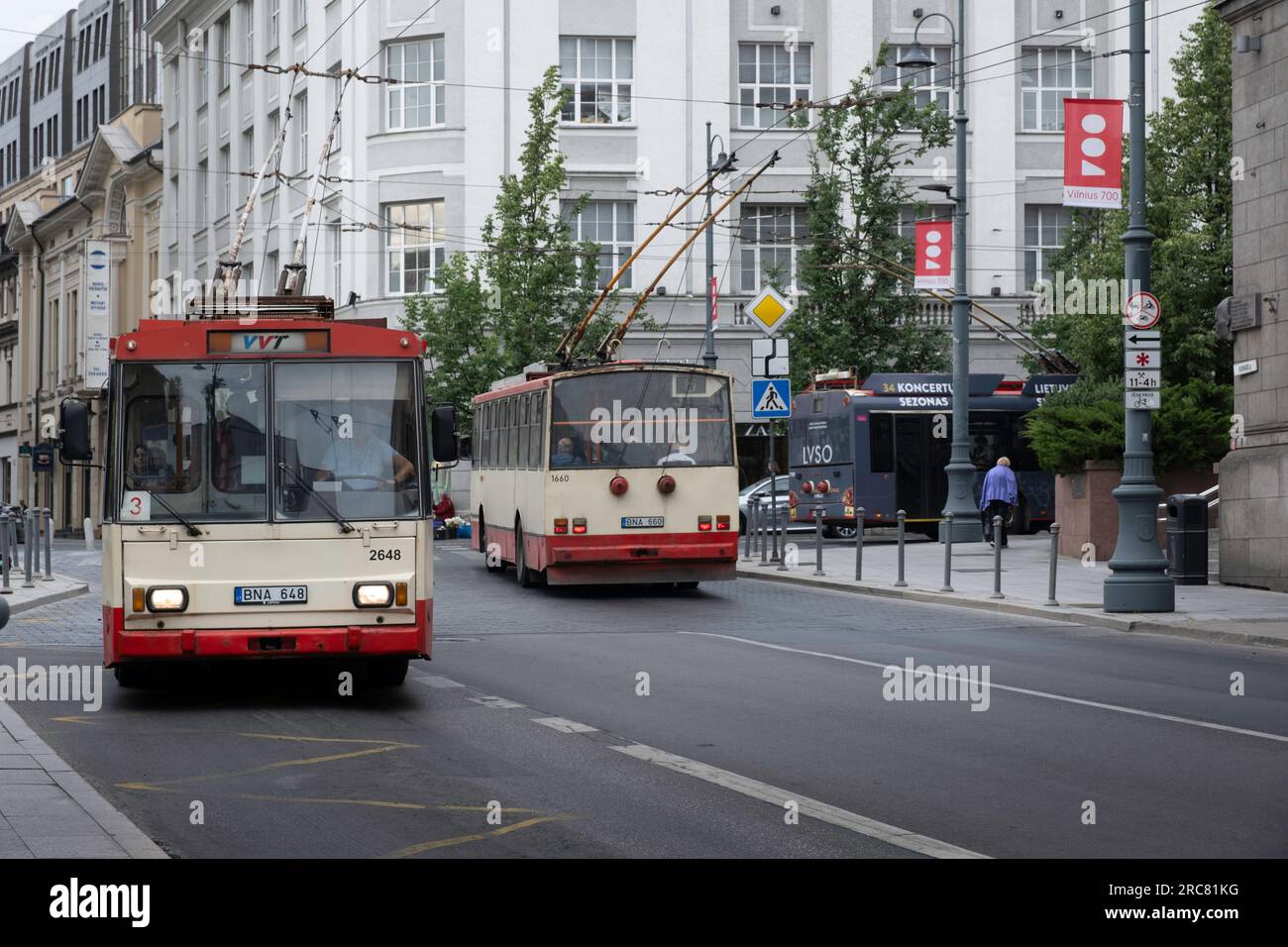 Due vecchi tram Skoda passano in una strada nel centro di Vilnius, in Lituania. Trasporti pubblici VVT (Vilniaus viešasis Transportas) Foto Stock