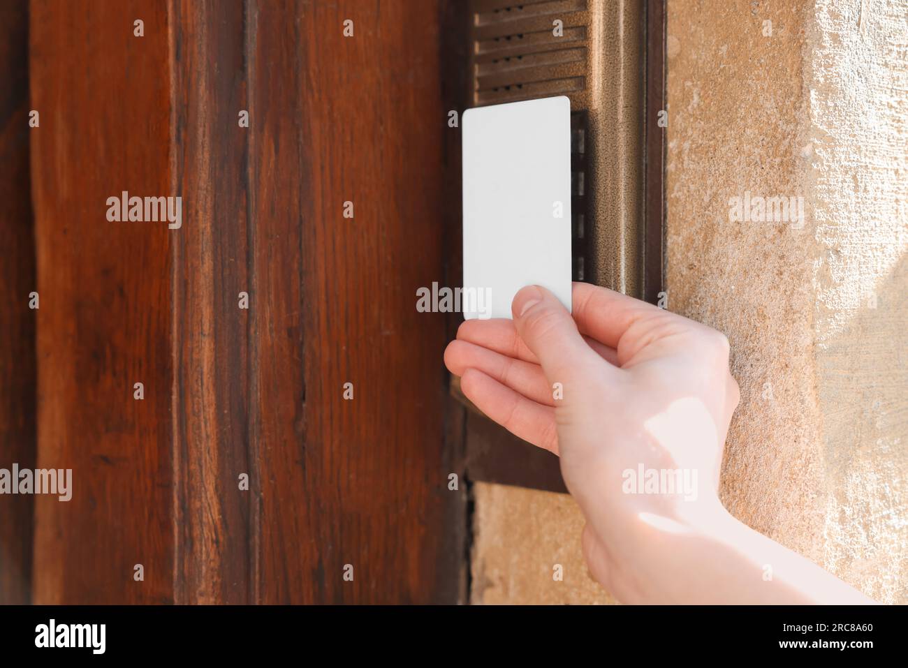 Donna che apre la serratura della porta con la chiave a scheda all'aperto, primo piano Foto Stock