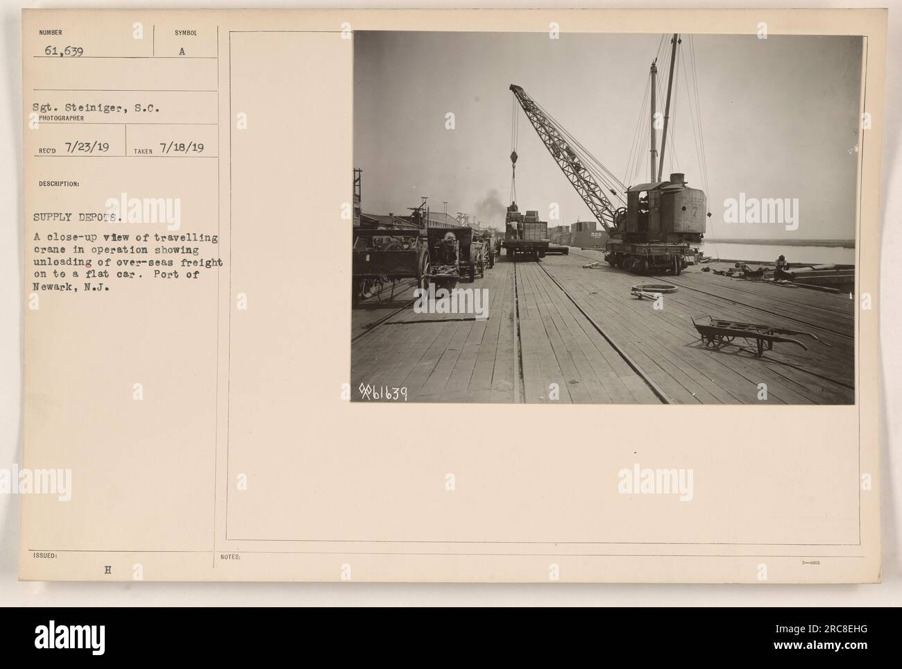 Una gru mobile è in funzione al porto di Newark nel New Jersey. La gru sta scaricando merci oltremare su una carrozza piana, come parte delle attività di deposito di rifornimenti durante la prima guerra mondiale. Questa foto è stata scattata il 18 luglio 1919 dal sergente Steiniger, S.C.. Foto Stock