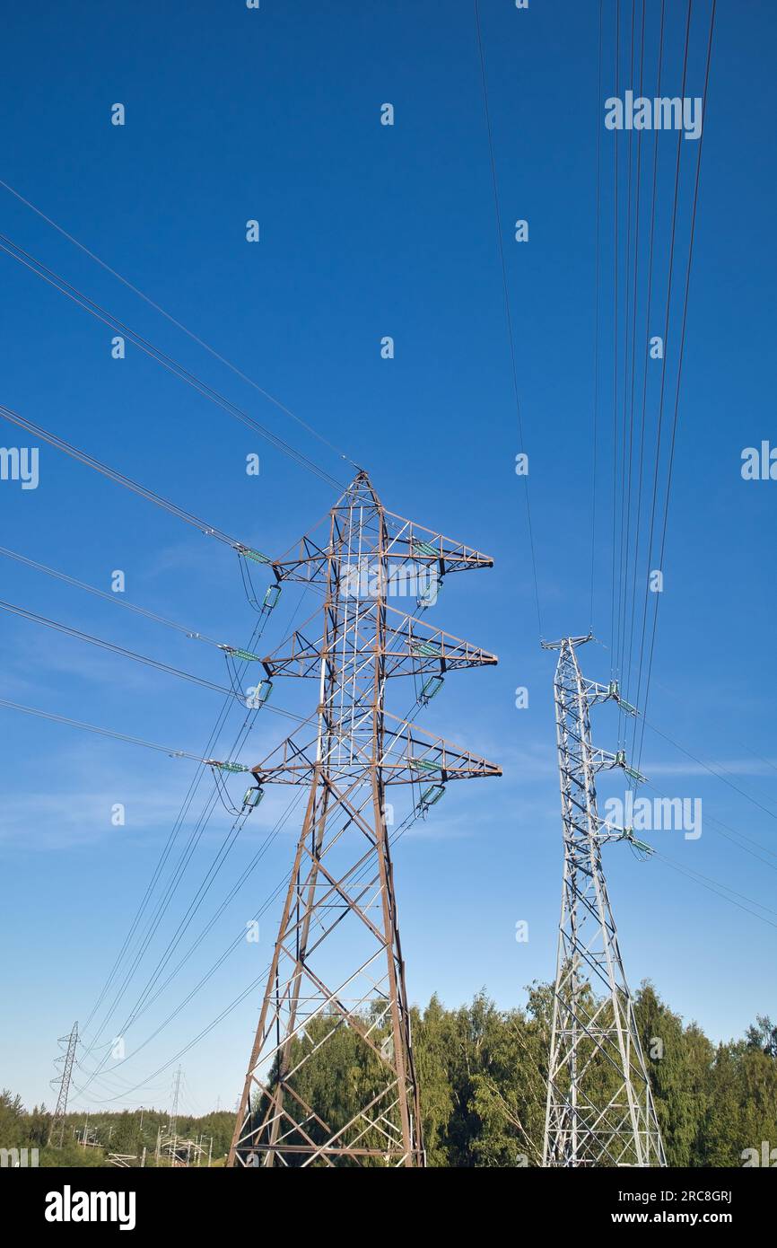 Linee ad alta tensione e piloni di potenza contro il cielo blu Foto Stock