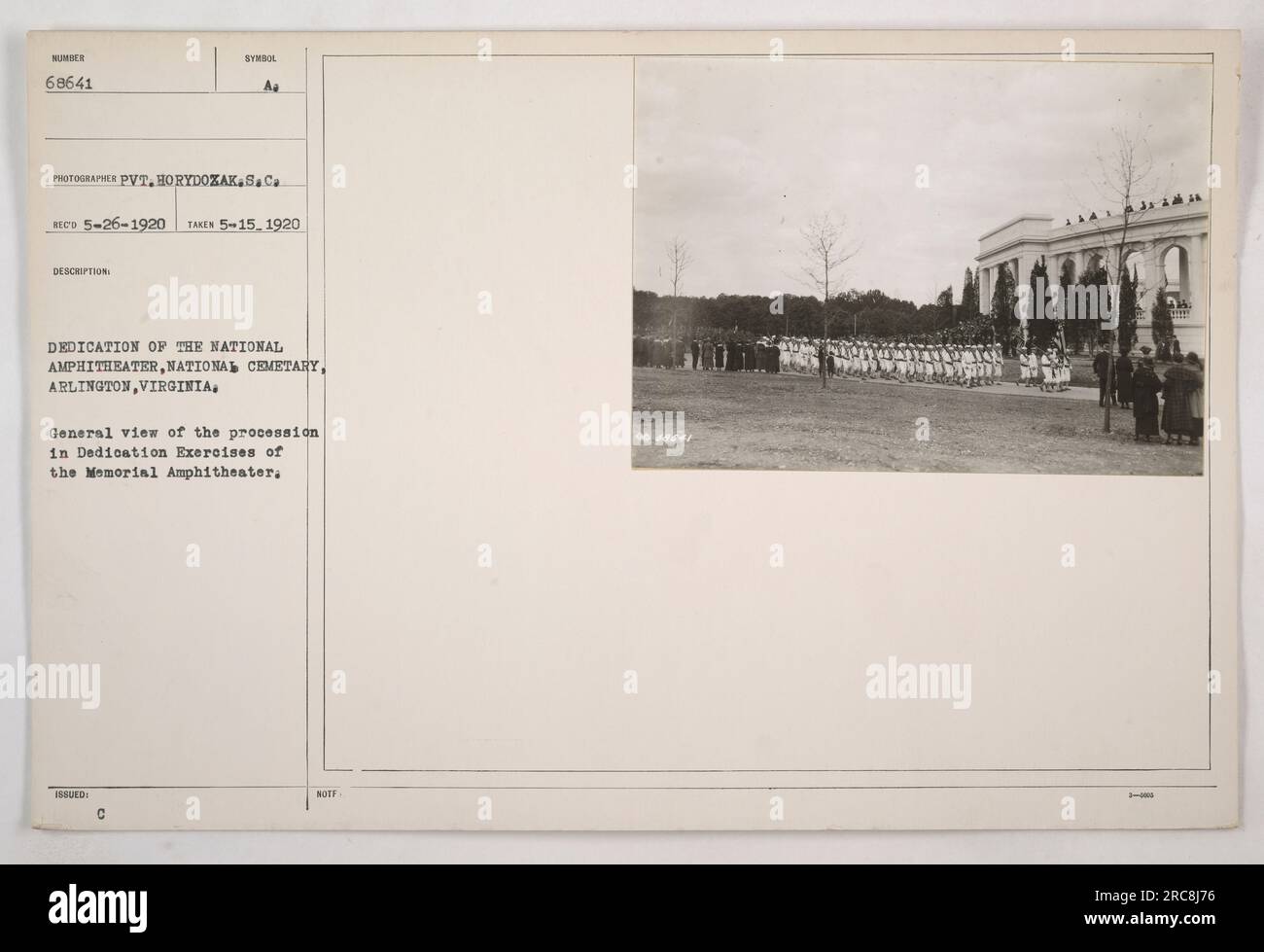 Questa immagine mostra gli esercizi di dedica del Memorial Amphitheatre presso l'Arlington National Cemetery di Arlington, Virginia. Raffigura una processione durante la cerimonia di dedica. La foto è stata scattata il 15 maggio 1920 e l'immagine è stata catturata da Pvt. Horydozak. L'evento si è svolto il 26 maggio 1920. Il simbolo riconosciuto nella descrizione è "RECO". Foto Stock