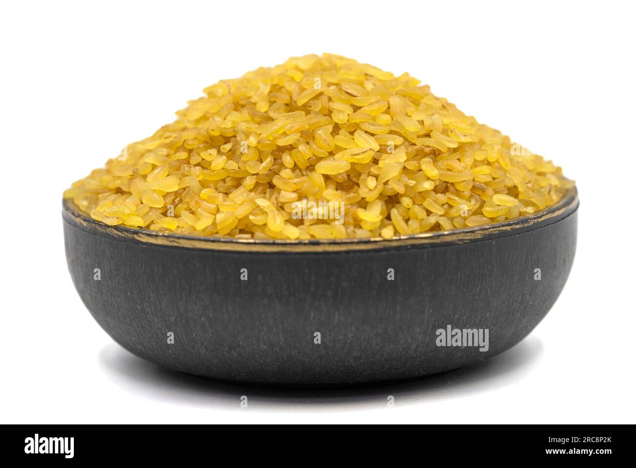 Grano bulgur grezzo isolato su sfondo bianco. Bulgur secco crudo nel recipiente Foto Stock