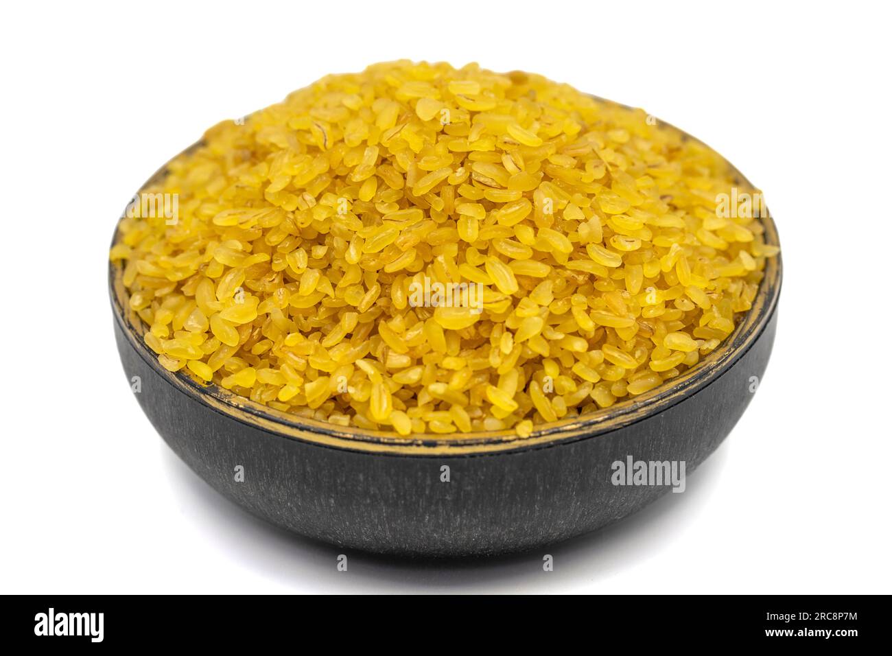 Grano bulgur grezzo isolato su sfondo bianco. Bulgur secco crudo nel recipiente Foto Stock