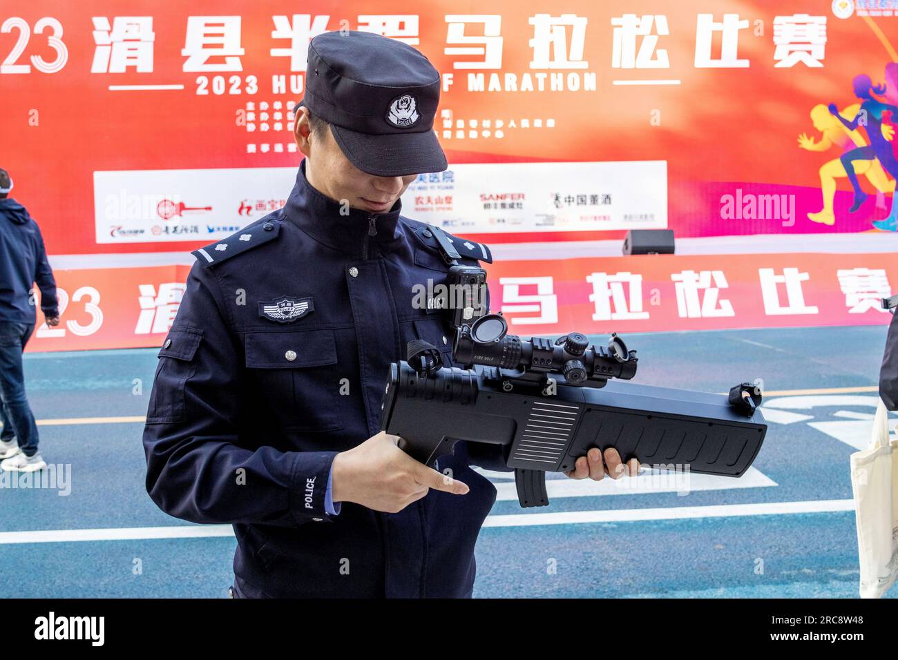 ANYANG, CINA - 7 MAGGIO 2023 - gli agenti di polizia detengono attrezzature di contromisure per aerei senza equipaggio in un evento sportivo su larga scala nella contea di Hua, Anyang cit Foto Stock