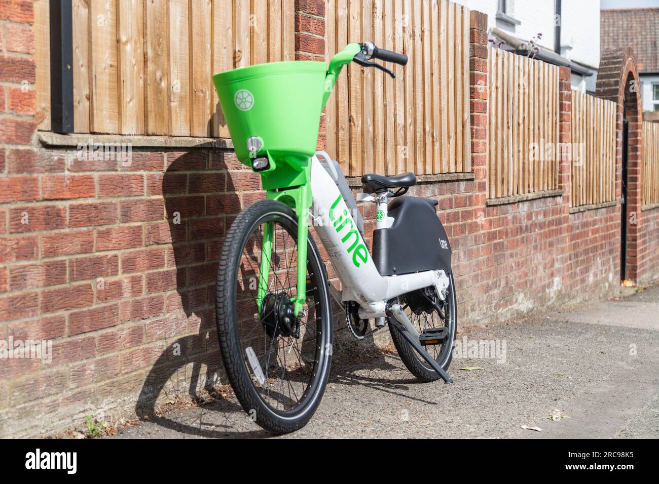 LONDRA, Regno Unito - 13 LUGLIO 2023: Una bici a noleggio Lime è stata lasciata contro una recinzione in una zona residenziale di Londra Foto Stock