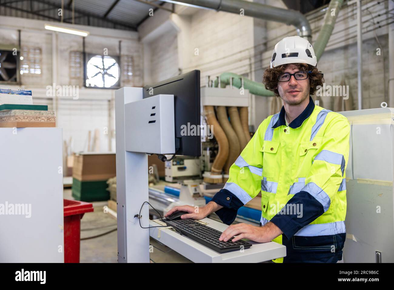 giovane tecnico ingegnere caucasico lavoratore del personale maschile che sorride nella fabbrica di mobili dell'industria moderna Foto Stock