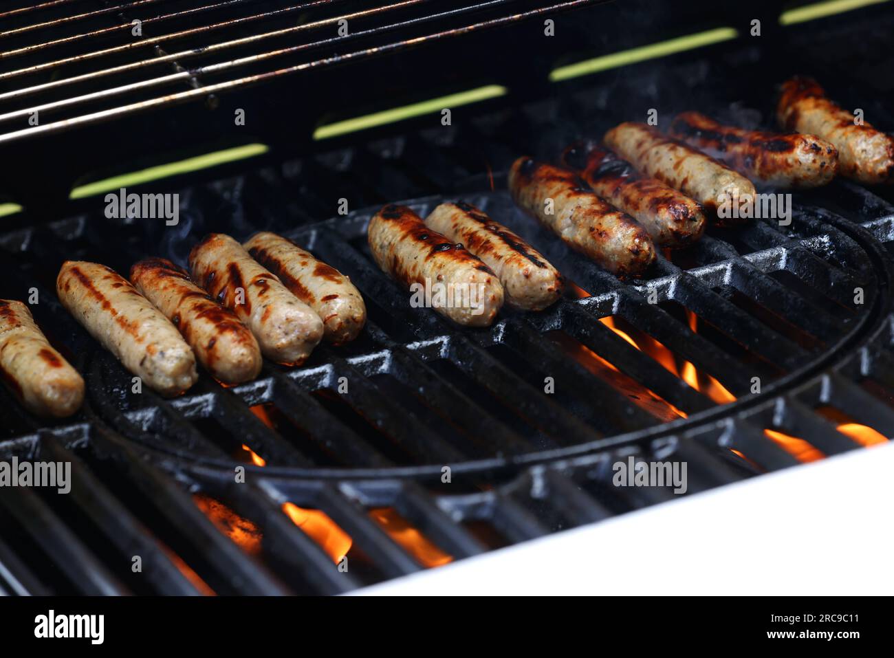 A Londra, Regno Unito, ci sono un sacco di gustose salsicce a base di carne cucinate su un barbecue. Foto Stock