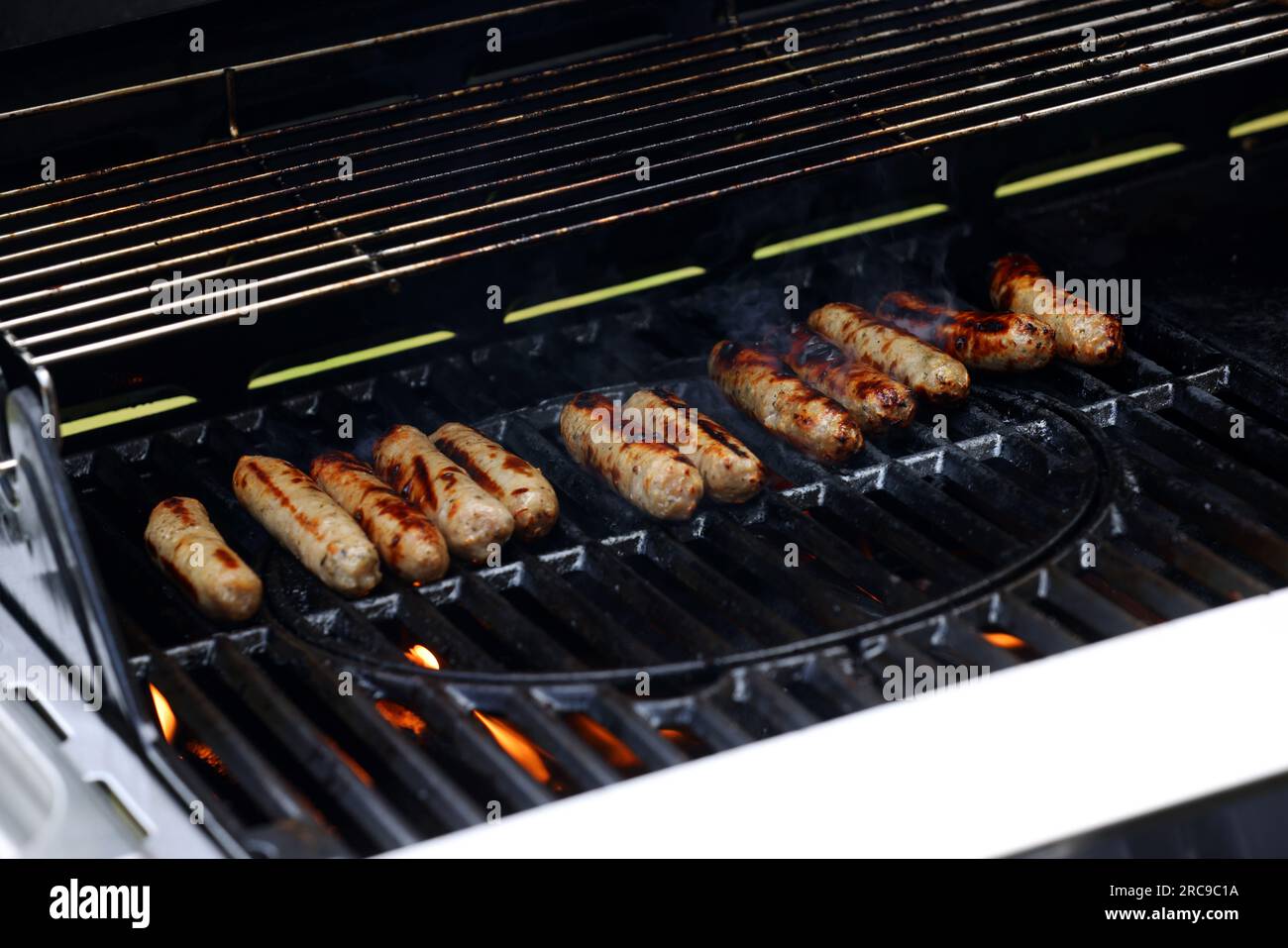 A Londra, Regno Unito, ci sono un sacco di gustose salsicce a base di carne cucinate su un barbecue. Foto Stock