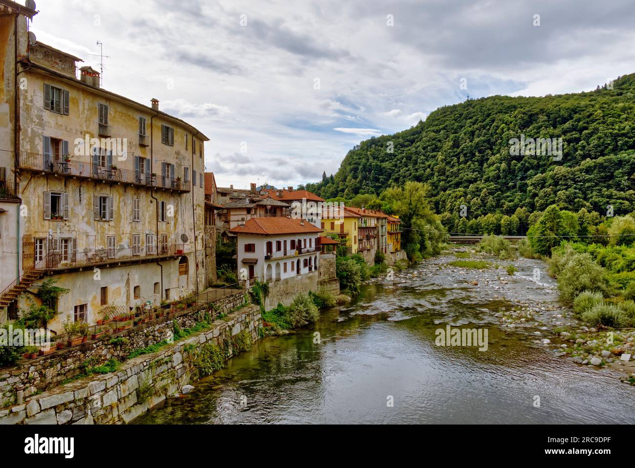 Il fiume Sesia scorre attraverso il centro storico dell'abitato alpino di Varallo Foto Stock