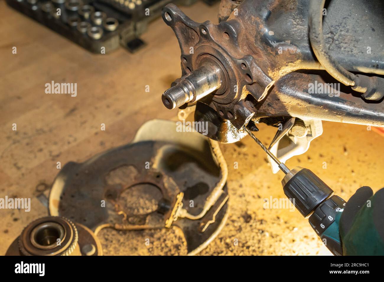 Il meccanico dell'auto esegue una filettatura. Riparare il cuscinetto del mozzo ruota. Officina. Foto Stock