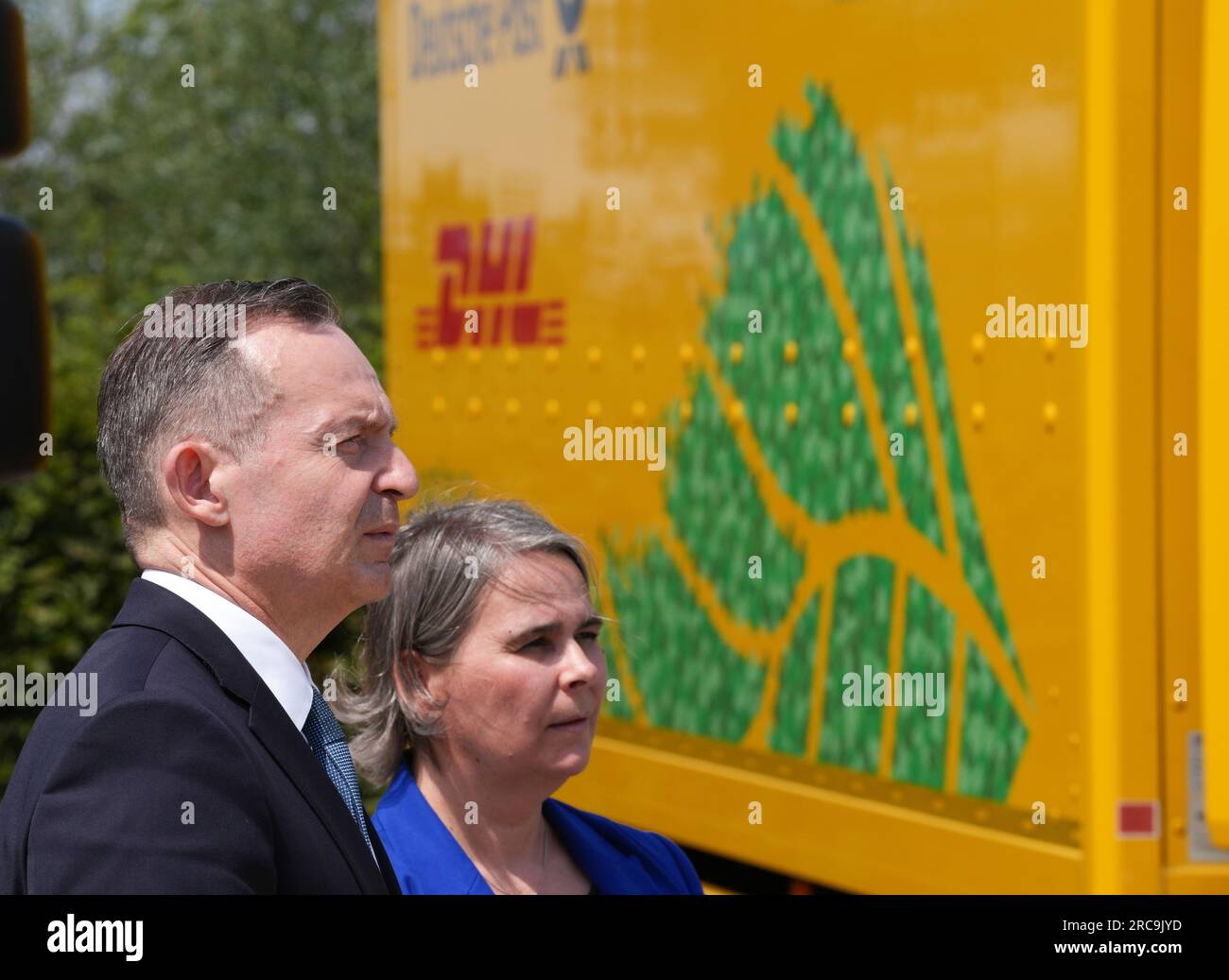 13 luglio 2023, Brandeburgo, Schönefeld: Volker Wissing (FDP, l), Ministro federale dei trasporti e degli affari digitali, e Nikola Hagleitner, membro del Consiglio di amministrazione di Poste e Parcel Germany, si trovano accanto a un camion Volvo FL Electric 4x2 alimentato elettricamente durante un evento stampa presso il Deutsche Post and mail Center di Schönefeld. Deutsche Post DHL ha presentato 13 carrelli elettrici che verranno utilizzati per il trasporto di lettere e pacchi nel rispetto dell'ambiente. Foto: Soeren Stache/dpa Foto Stock