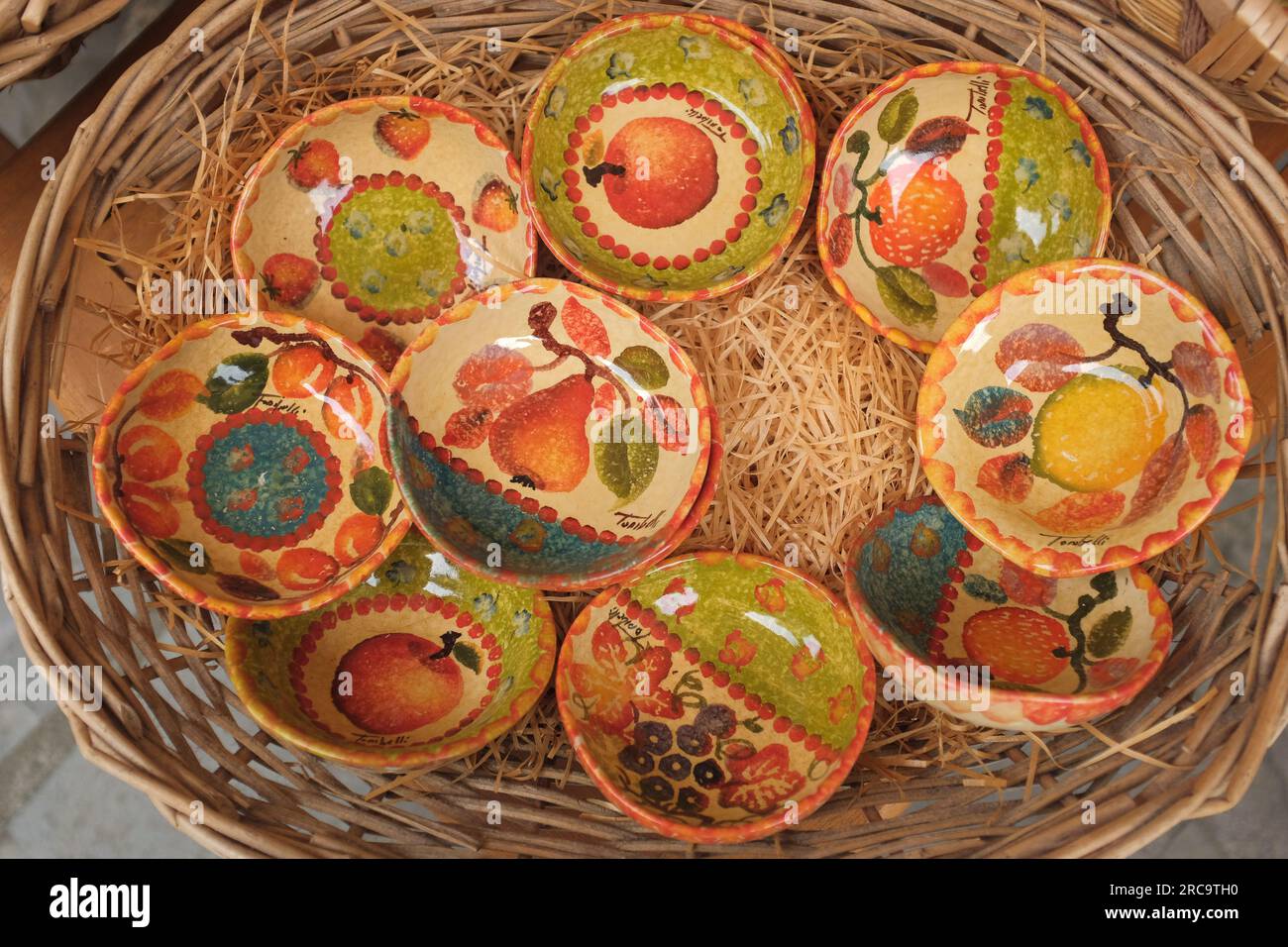 Cinque Terre, Italia - colorate ciotole in ceramica fruttata esposte su un cestino. Souvenir locali venduti a Riomaggiore, una cittadina di mare sulla Riviera Italiana. Foto Stock