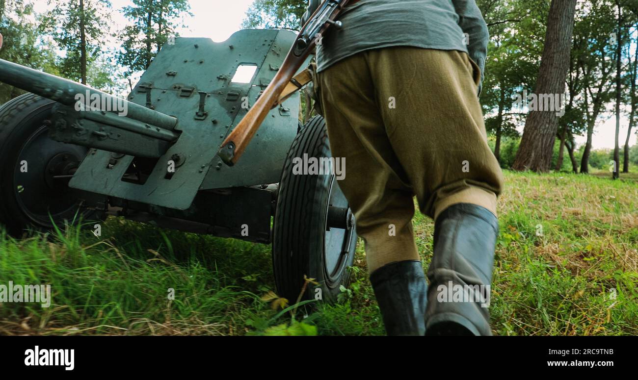 Un gruppo di reattori vestiti come soldati di fanteria dell'Armata Rossa russa della seconda guerra mondiale spostano la pistola anticarro sovietica da 45 mm in posizione di combattimento Foto Stock