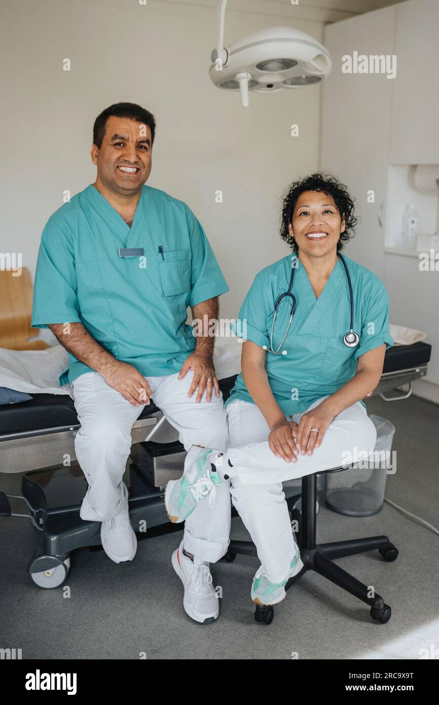 Ritratto di professionisti sanitari sorridenti maschili e femminili seduti in ospedale Foto Stock