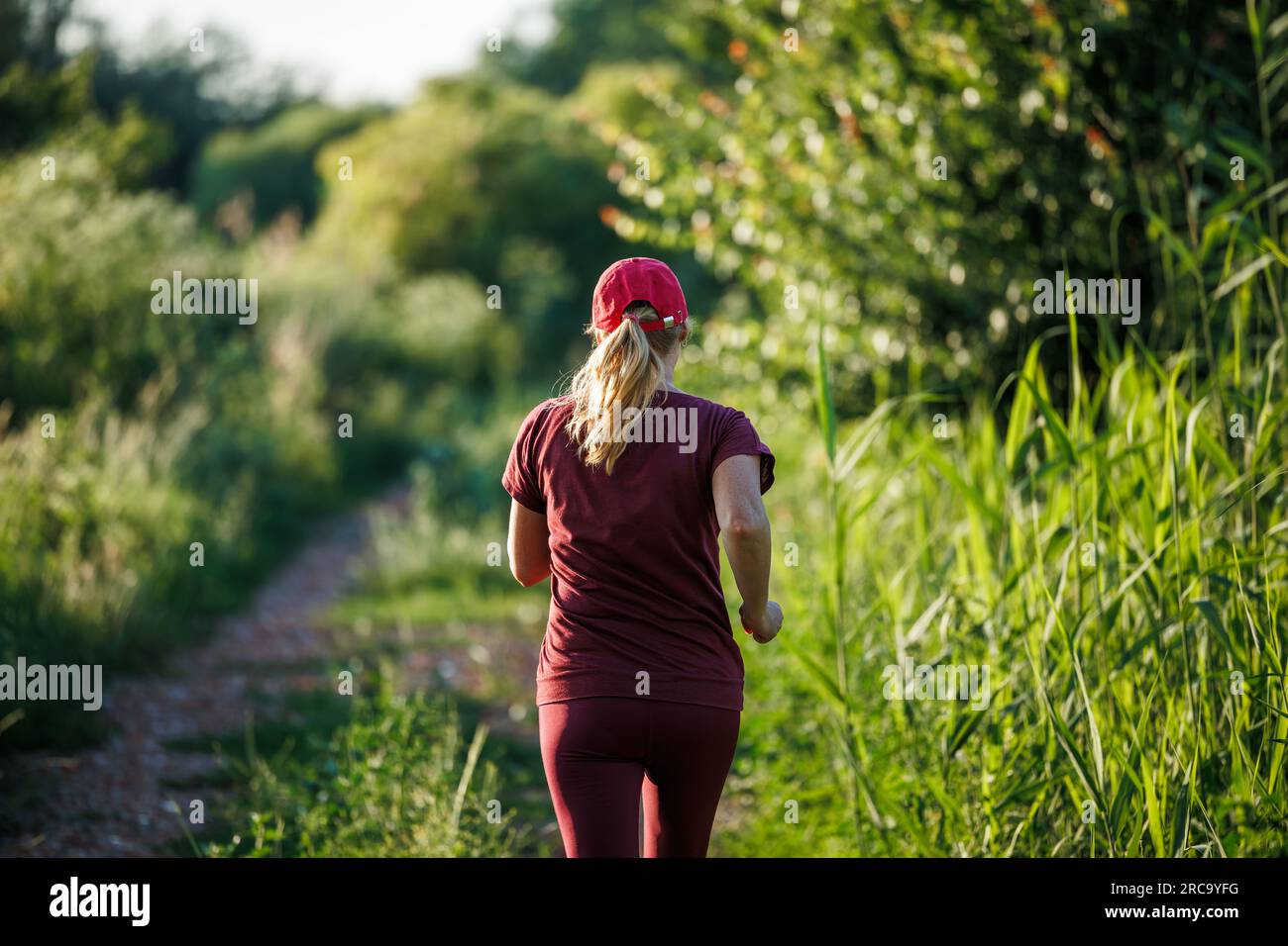 Donna che corre nella natura. Attività sportive e cardio all'aperto in estate Foto Stock
