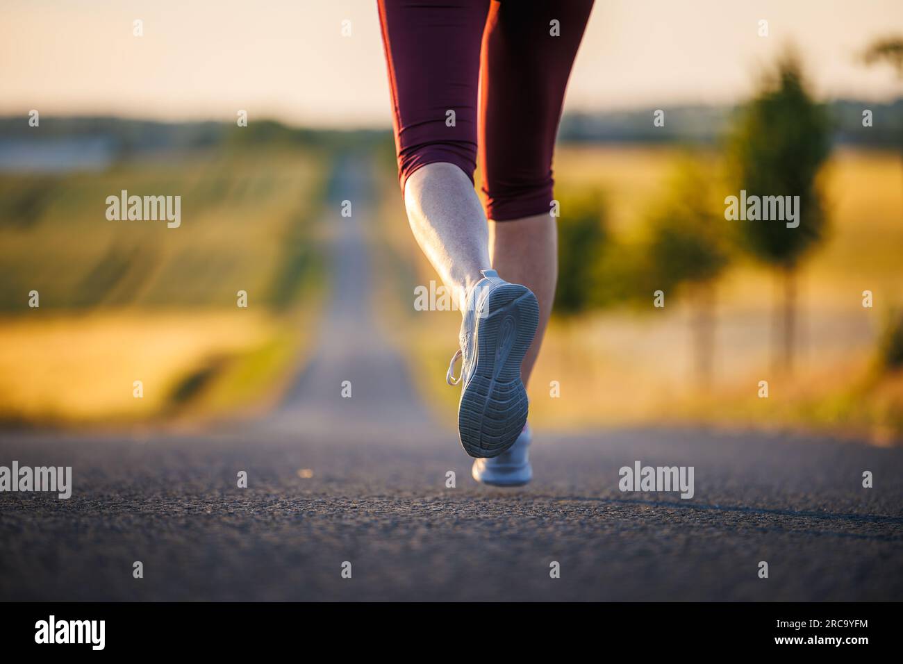 Donna con scarpa sportiva che corre su strada. Fitness all'aperto e allenamento sportivo Foto Stock
