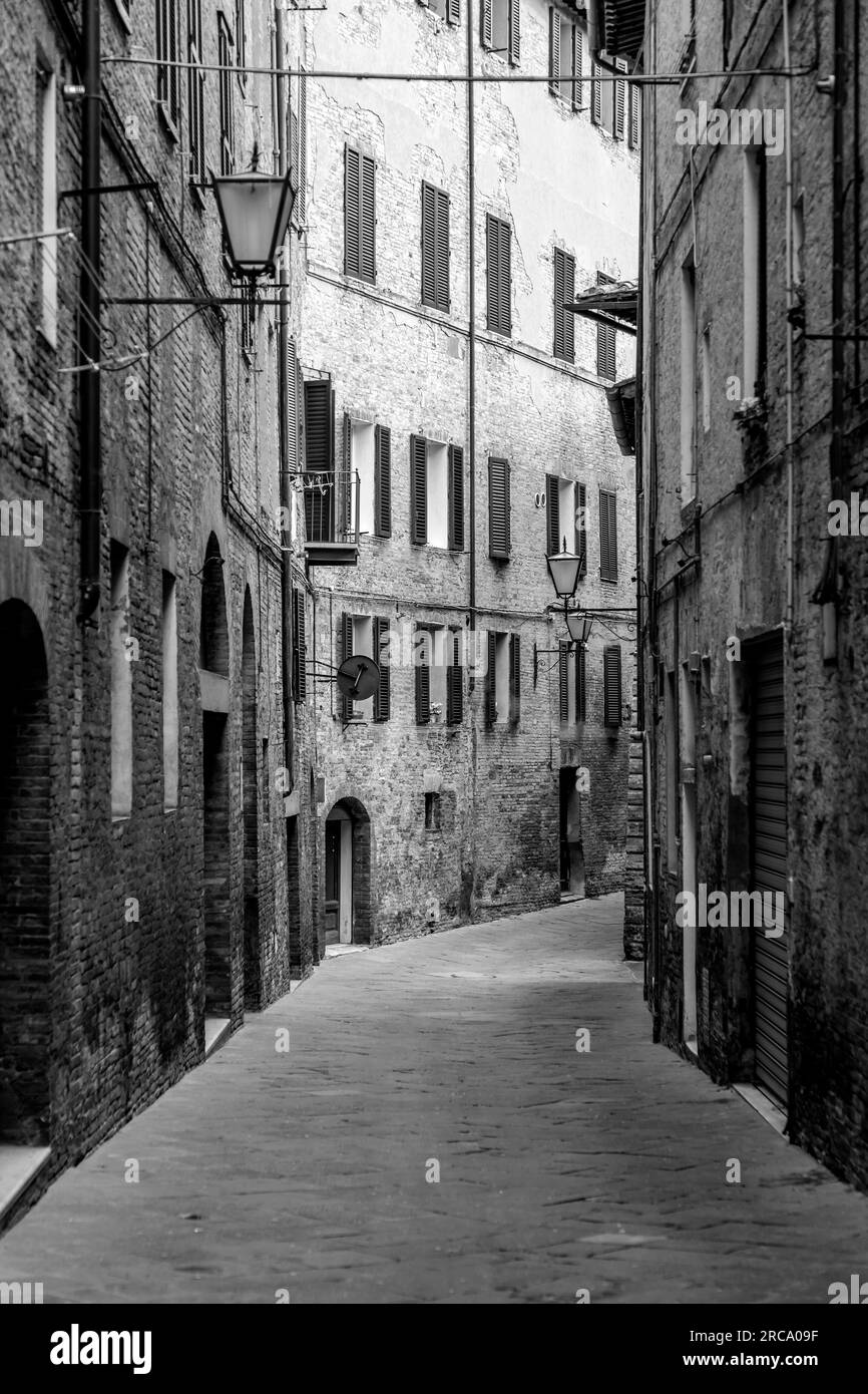 Architettura generica e vista sulla strada dalla storica città italiana di Siena in Toscana. Foto Stock