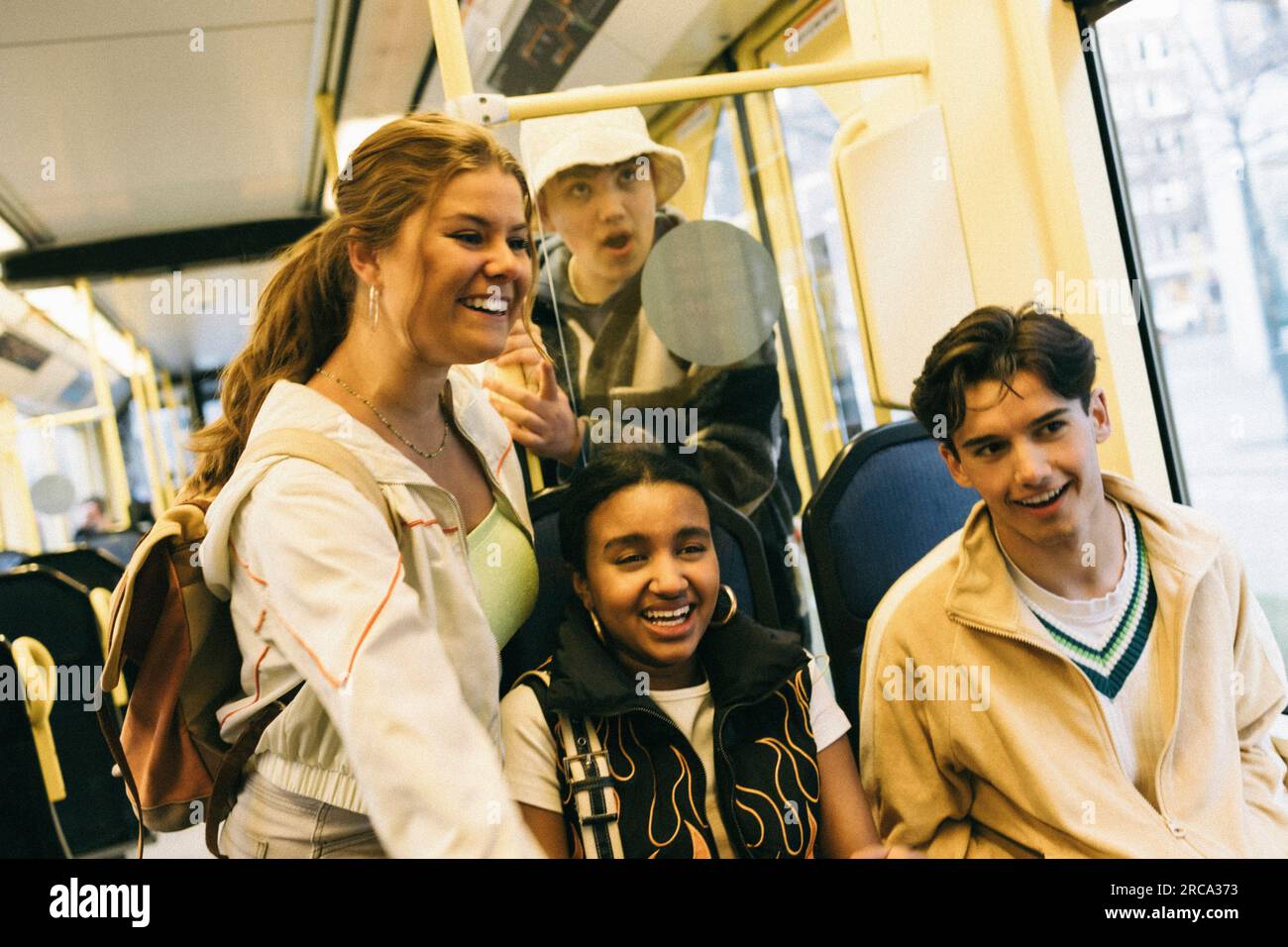 Felici amici maschi e femmine che si divertono mentre viaggiano in treno Foto Stock