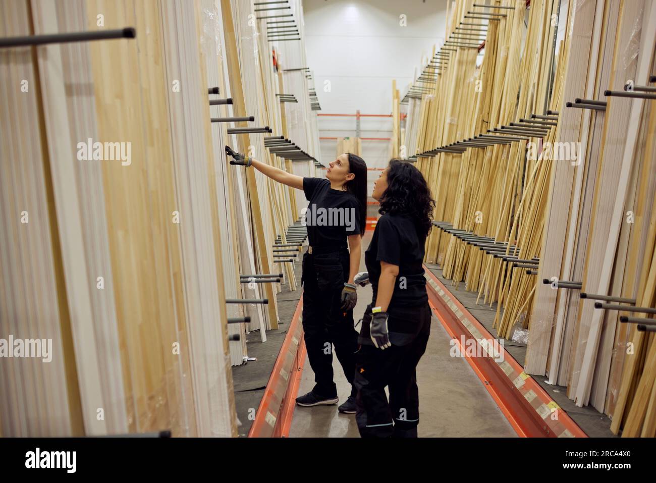 Colleghi femminili multirazziali che discutono sulle tavole nell'industria del legname Foto Stock