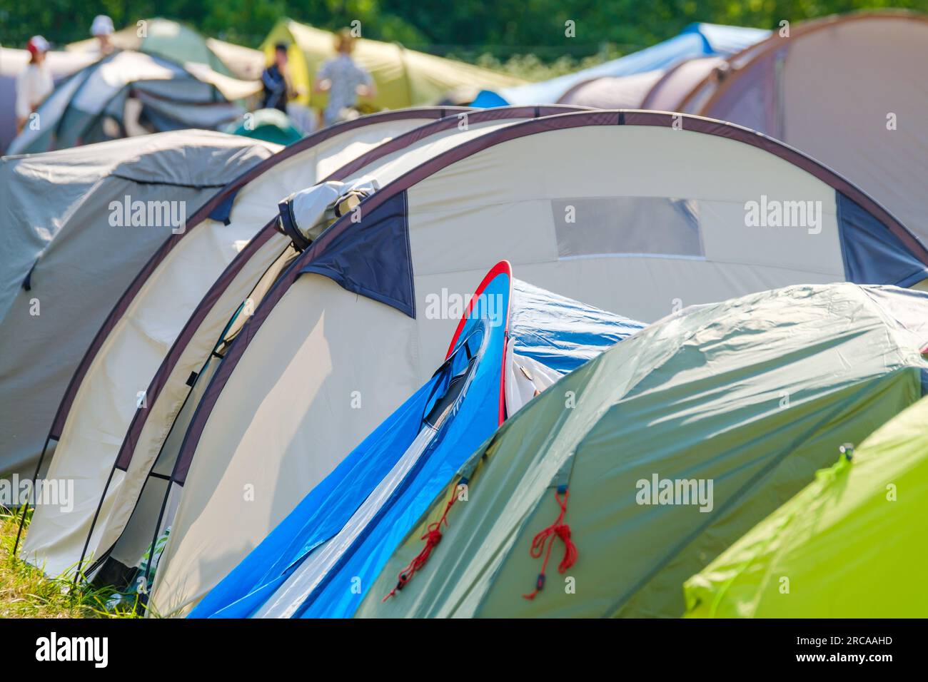 Fila di tende colorate collocate sul terreno del campeggio durante il festival musicale nelle giornate di sole Foto Stock