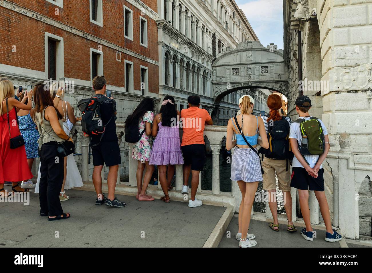 I turisti sul Ponte della paglia ammirano e fotografano il famoso Ponte dei Sospiri sul canale Rio di Palazzo, Venezia, Veneto, Italia Foto Stock