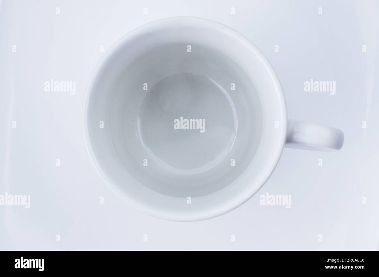 Raffinata porcellana: Tazza vuota su un piatto bianco, che trasmette raffinatezza e buon gusto. Foto Stock Raffinata porcellana: Tazza vuota su un piatto bianco, che trasmette raffinatezza e buon gusto. Foto Stock