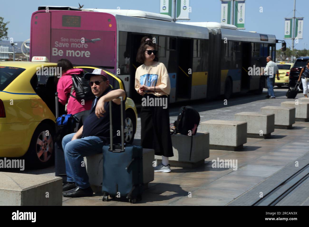 Atene Grecia Aeroporto Internazionale di Atene (AIA) Eleftherios Venizelos famiglia in attesa di un taxi con i bagagli Foto Stock