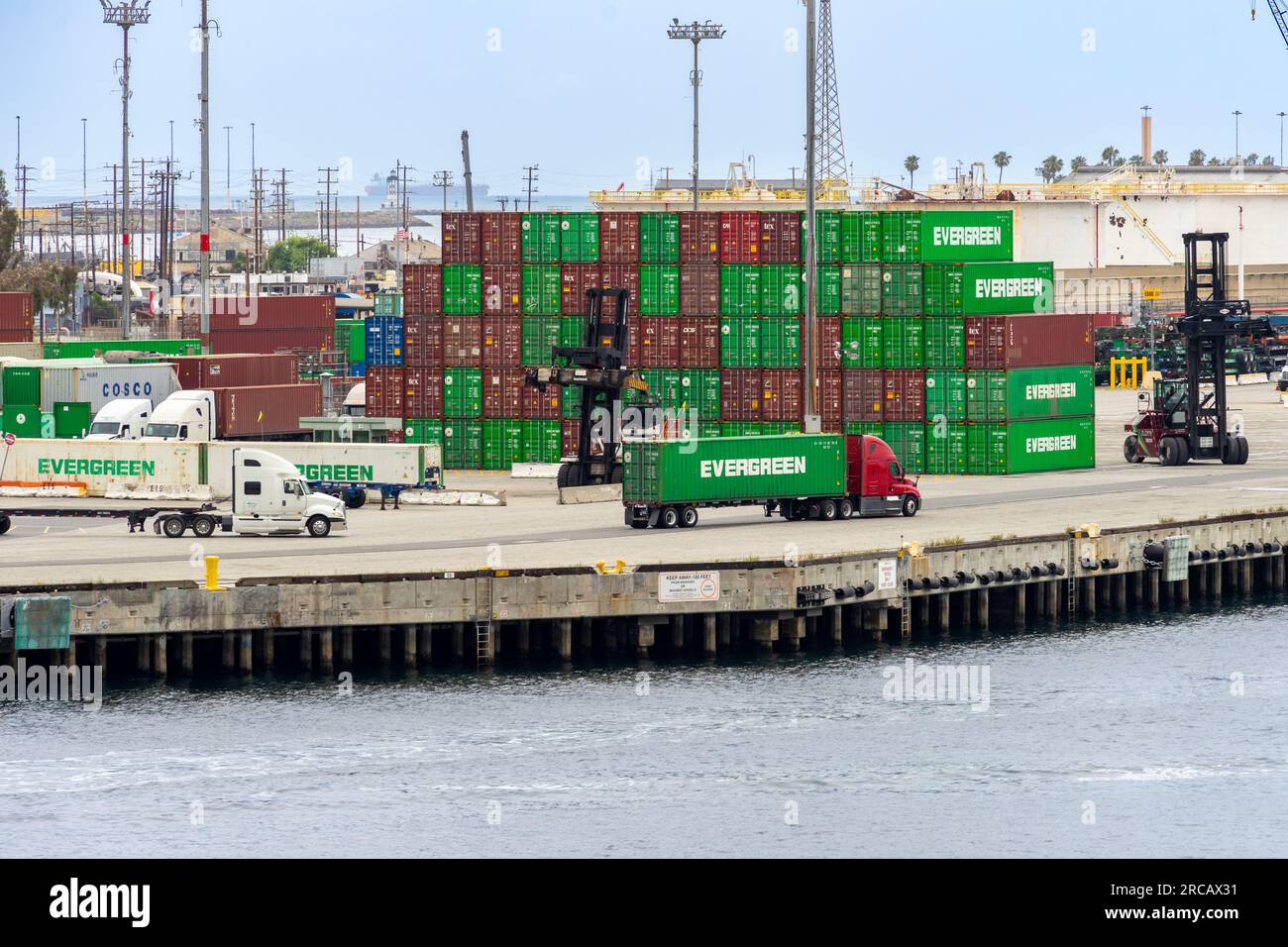 San Pedro, CA, Stati Uniti d'America – 2 giugno 2023: Semicamion e container per spedizioni presso Terminal Island, situato presso il porto di Los Angeles a San Pedro, Califo Foto Stock