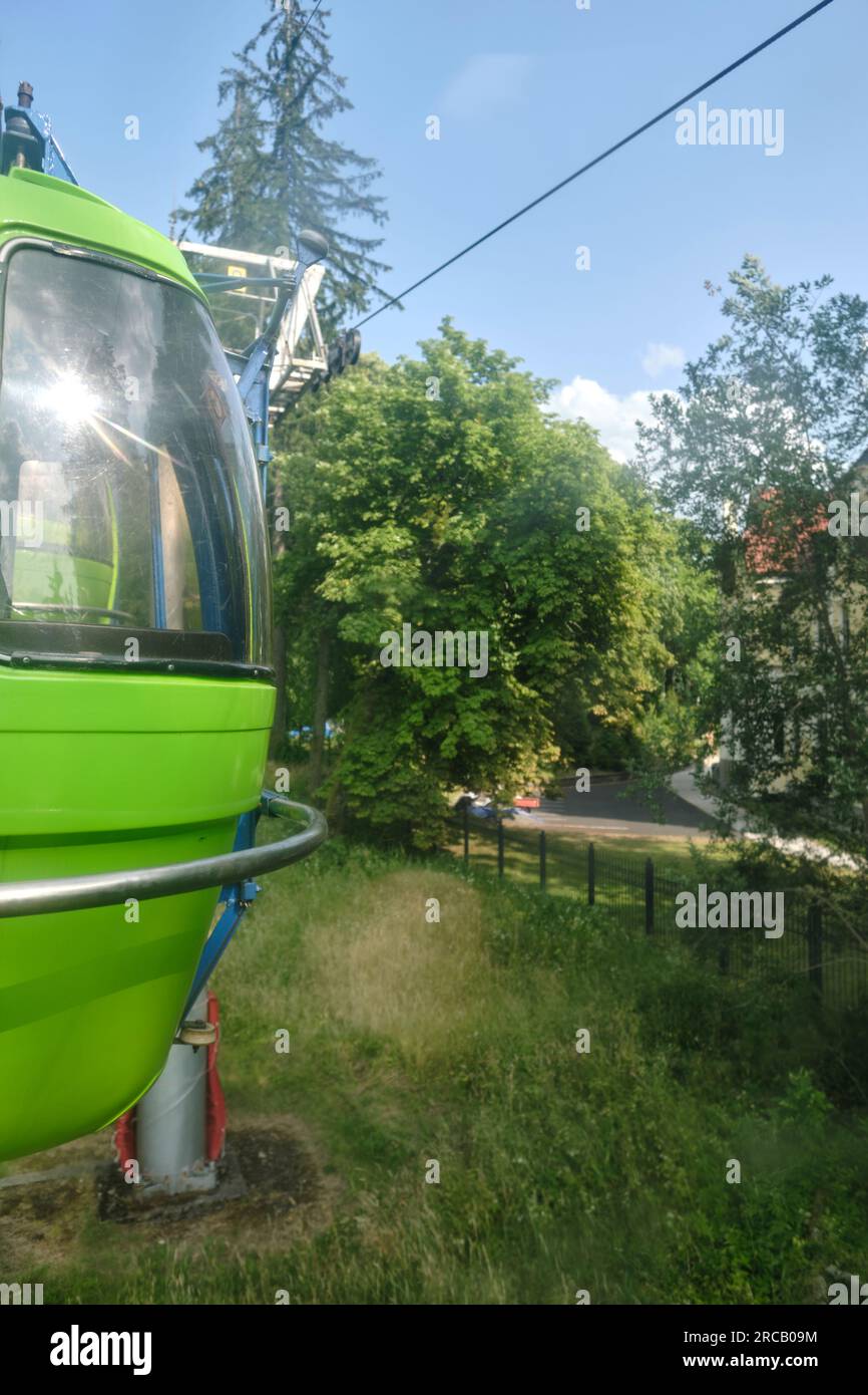 Vista da una cabina funicolare in una soleggiata giornata estiva. Viaggio di famiglia in funivia verde verso l'Hotel Krakonos. Vacanze estive rilassate e attive. Foto Stock