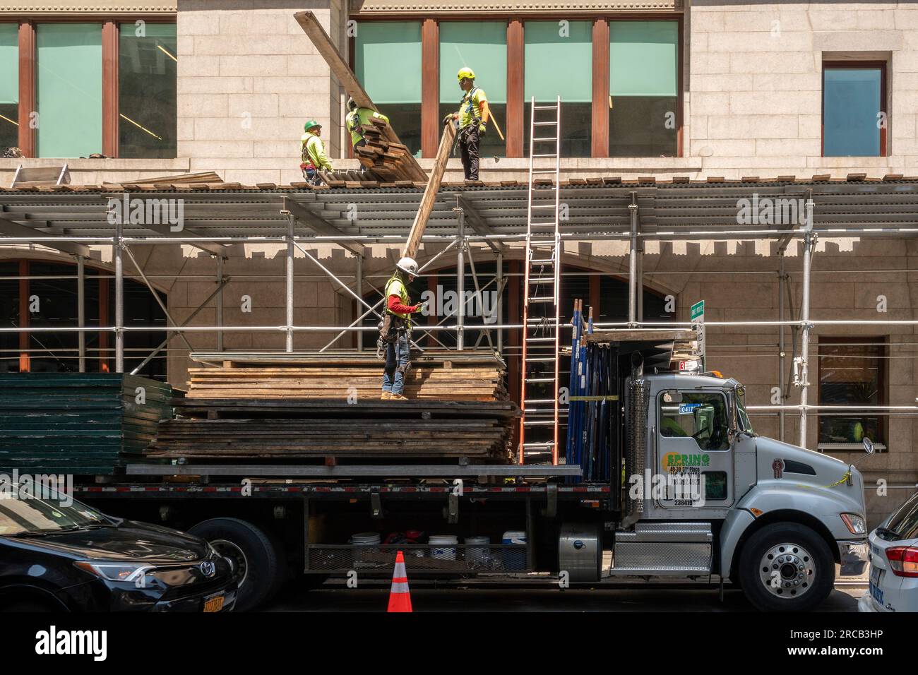 I lavoratori formano una catena umana per decostruire impalcature nel quartiere Flatiron di New York mercoledì 5 luglio 2023. (© Richard B. Levine) Foto Stock