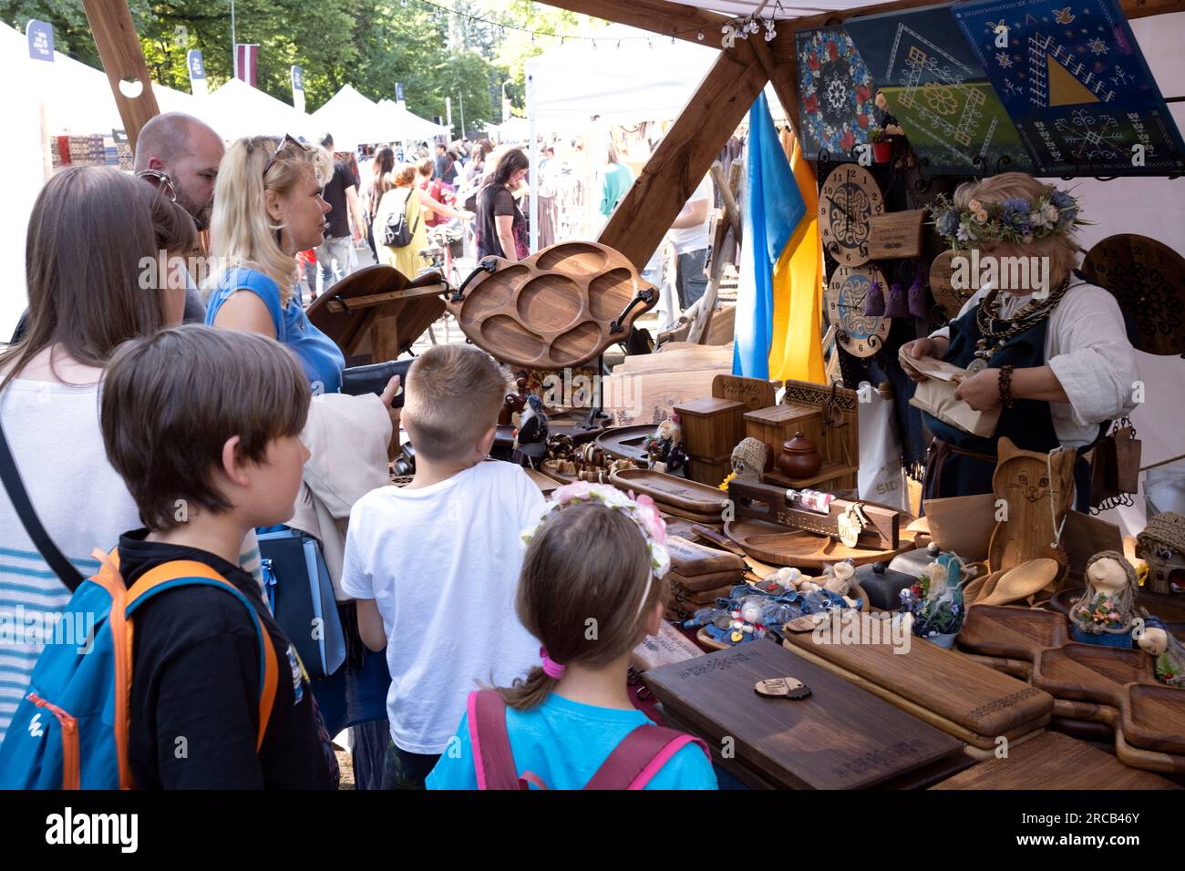 Visitatori allo stand, artigiani che vendono prodotti in legno nella città di riga, Lettonia Foto Stock