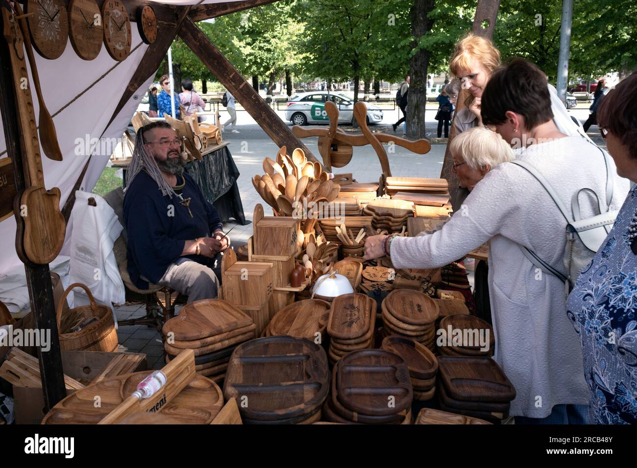 Visitatori allo stand, artigiani che vendono prodotti in legno nella città di riga, Lettonia Foto Stock