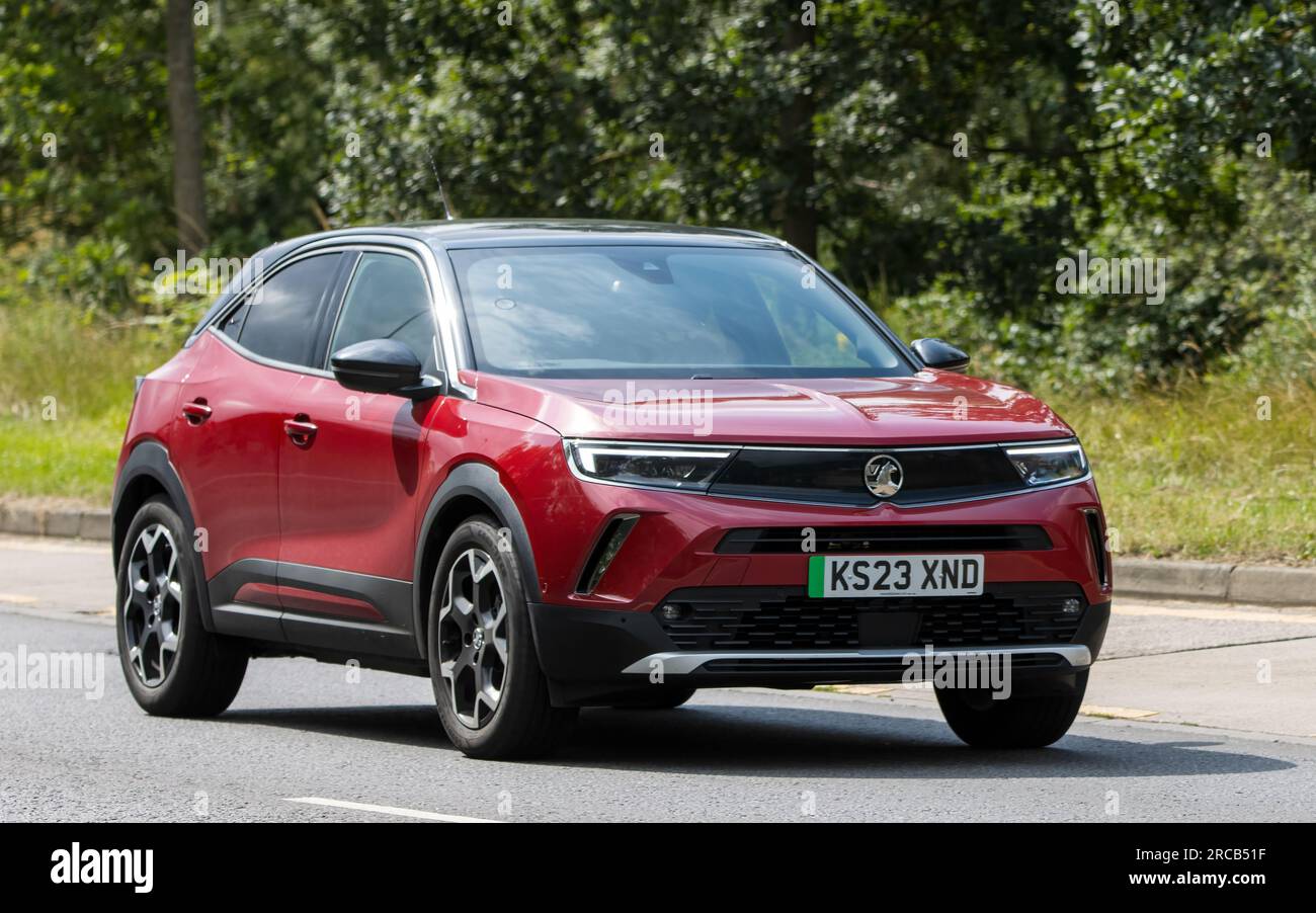 Milton Keynes, Regno Unito - 13 luglio 2023: 2023 auto elettrica rossa VAUXHALL MOKKA ULTIMATE EV che guida su una strada inglese Foto Stock