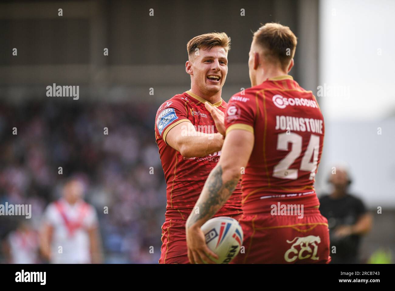 St Helens, Inghilterra - 13 luglio 2023 - Tom Davies si congratula con il meta marcatore Tom Johnstone dei draghi catalani . . Betfred Super League, St. Helens vs Catalan Dragons al Totally Wicked Stadium, St. Helens, Regno Unito Foto Stock